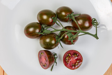 Branch of tomatoes cherry kumato and two halves of tomato