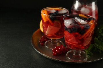 Delicious Red Sangria and ingredients on black table, space for text