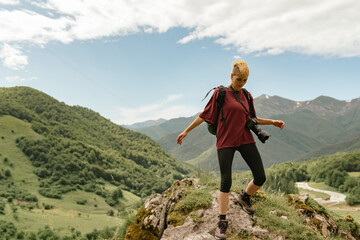 Naklejka premium young mountaineer woman with photo camera hiking