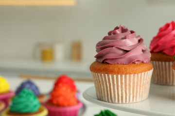 Delicious cupcakes with colorful cream on stand, closeup. Space for text