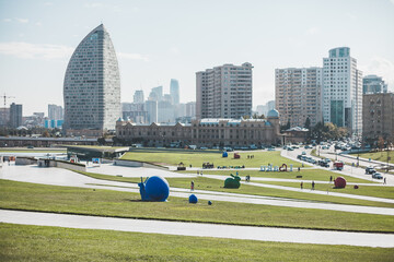 City view with modern and ancient buildings near the park in Baku, Azerbaijan. Modern art statues...