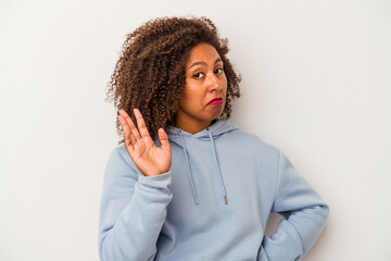 Young african american woman with curly hair isolated on white background rejecting someone showing a gesture of disgust.