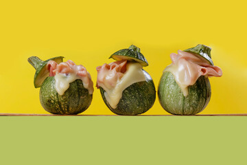 Baked baby squash with ham, cheese gratin with a yellow, green and purple background.