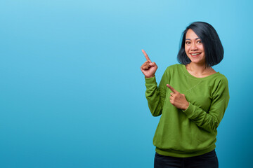 Attractive Asian woman wearing casual clothes smiling and pointing with two hands to the side