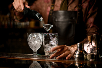 several crystal glasses in which poured ice cube from steel scoop