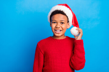 Photo of pretty charming dark skin kid dressed sweater headwear arm bubo smiling isolated blue...