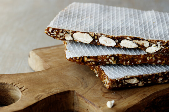 Turron nougat dessert with almond nuts and sesame seeds with honey close-up.