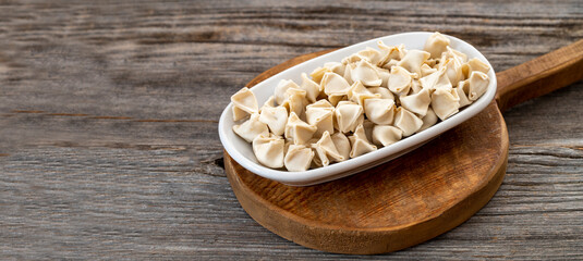 frozen ravioli on wood background. Mediterranean cuisine delicacies. Copy space
