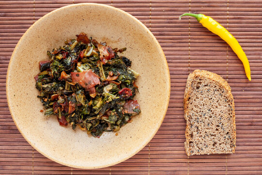 Leafy fried dish with endive leaves, ginger, bacon, garlic and sweet soy sauce. Top view meal..
