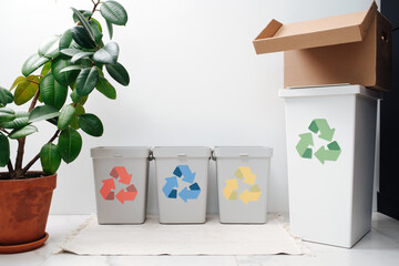 Small cute recycle bins on the table with differently colored arrows on them