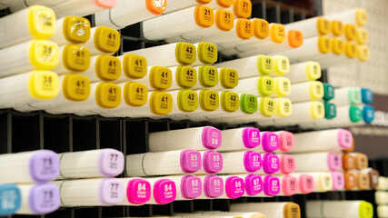 Alcohol markets on the shelf of a stationery store. Professional sketching markers are sold per piece at art stores for artists. Stationery store shelf with drawing accessories close-up.