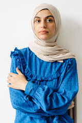 Middle eastern woman in headscarf posing with arms crossed