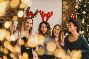 Fototapeta na wymiar Multiracial Group Of Female Friends Celebrating Holidays Together And Taking Selfie Near Christmas Tree
