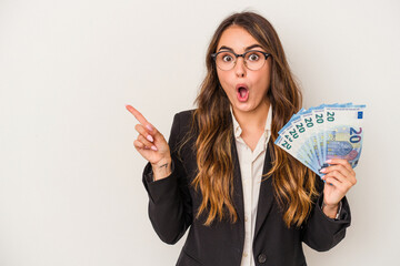 Young caucasian business woman holding banknotes isolated on white background pointing to the side