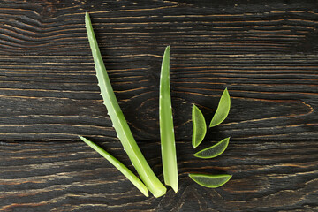 Aloe vera leaves and slices on wooden background