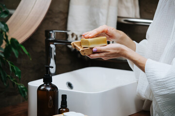 Soap dish in hands of a mature woman with an eco soap block