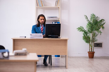 Fototapeta premium Young male employee working at workplace