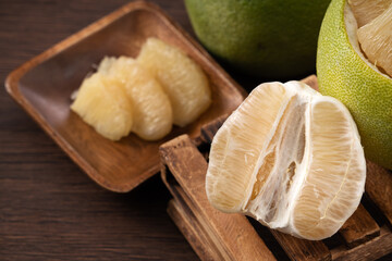 Fresh pomelo fruit on wooden table background.