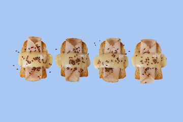 Toasted bread with ham, yellow cheese and flax seeds with a green, purple and blue background.