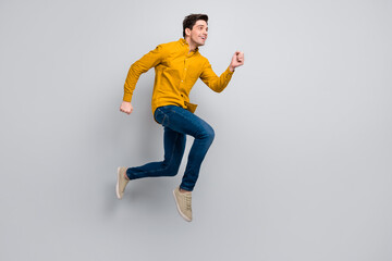 Fototapeta na wymiar Full length body size view of attractive cheery motivated man jumping running isolated over grey color background
