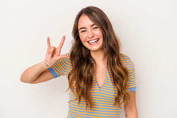 Young caucasian woman isolated on white background showing a horns gesture as a revolution concept.