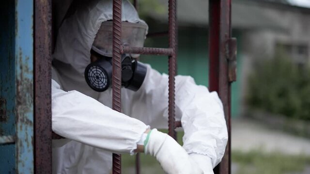 Man wearing protection suit, standing in metal constraction of building
