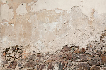Old stone building wall and crumbling plaster.
