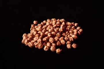 Top image or overhead shot of a group of chickpeas on black background. Food and beans. Dark food