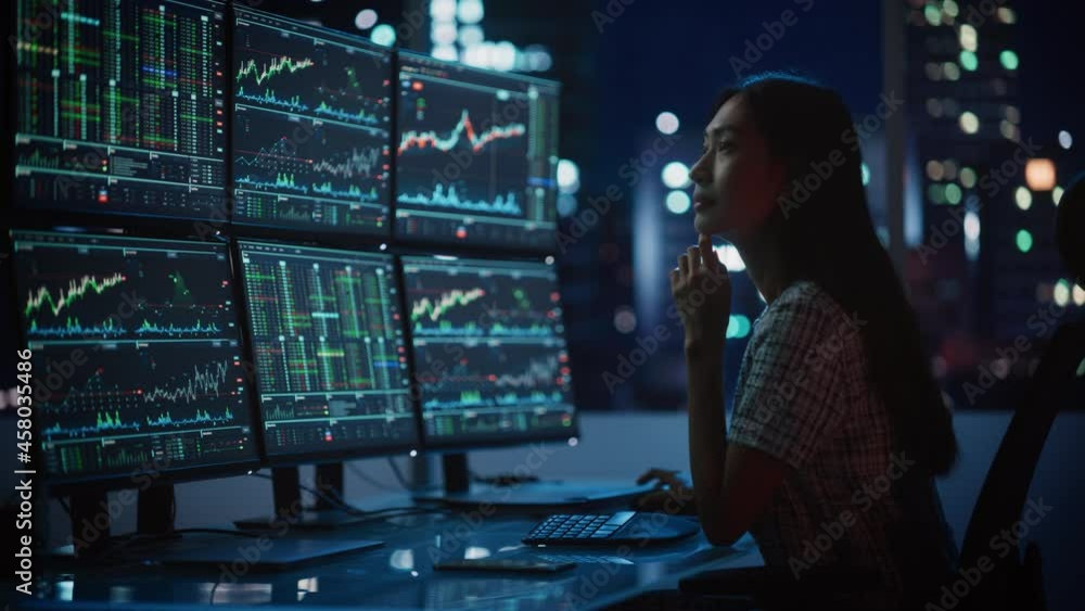 Poster portrait of a financial analyst working on computer with multi-monitor workstation with real-time st