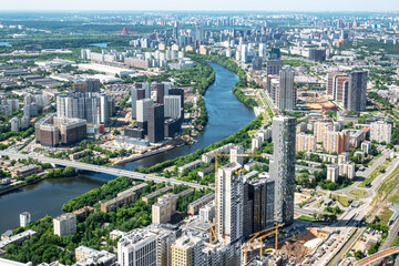 Fototapeta na wymiar Moscow, Russia - June 5, 2021: Panoramic aerial view of the city of Moscow, the Moskva river, bridges, residential buildings, skyscrapers on a sunny summer day