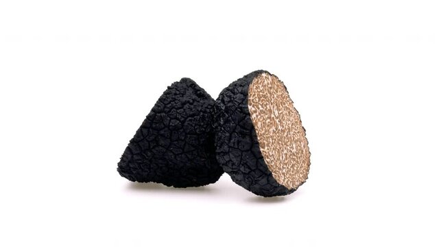 Two halves of black truffle mushrooms on white background.
