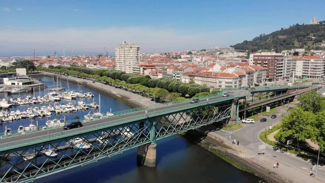 Viana do Castelo, Portugal - June 10, 2021: DRONE AERIAL FOOTAGE - Gustave Eiffel Bridge over the river Lima in Viana do Castelo. Aerial panoramic cityscape view of Viana and the Marina.