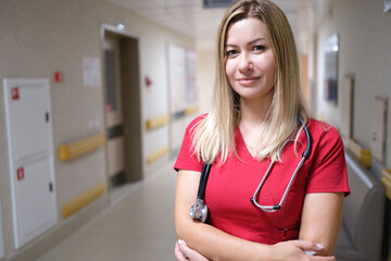 Young and attractive doctor on background of hospital corridor