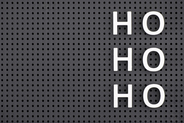 Ho, Ho, Ho spelled out with white letters on a gray pegboard.