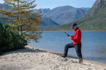 Fototapeta na wymiar man talking on a satellite phone in the mountains
