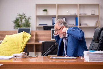 Aged businessman employee looking after newborn at workplace