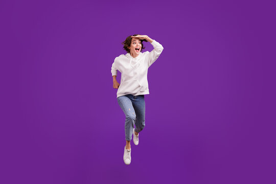 Full size photo of young exicted smiling female running fast traveling sightseeing isolated on violet color background