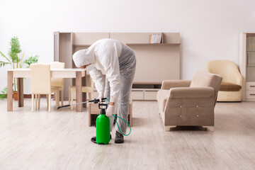 Young male contractor doing pest control at home