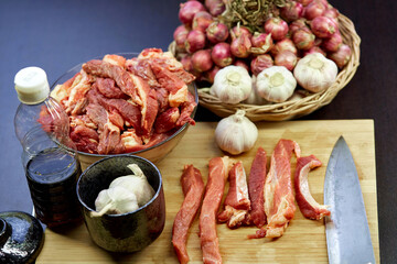 fresh raw meat in bowl glass with ingredients for cooking in kitchen