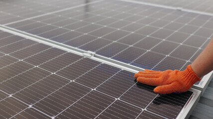 Unrecognizable man glove wiping solar panel from dust on sunny day. Close up of a young engineer...