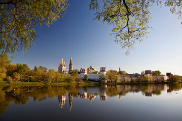 Fototapeta na wymiar Panorama of the architectural ensemble of the Novodevichy Monastery and its reflection in the pond on a spring morning. Moscow, Russia