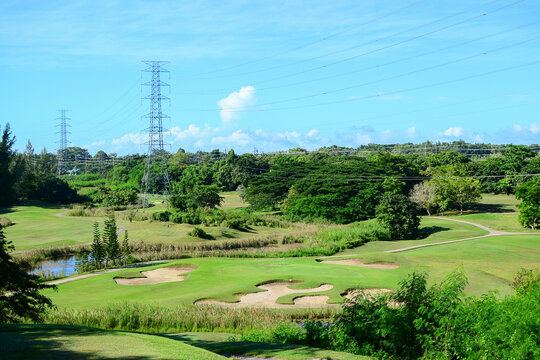 View of Golf Course with putting green, green grass, sand bunker, blue sky, and high voltage electric transmission tower background. Using for Golf field banner with a copy for your text. © SINPAKDEE