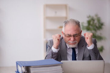 Old male employee unhappy with excessive work in the office