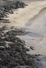 waves on the hard rocks and the sandy beach, Horta, Azores