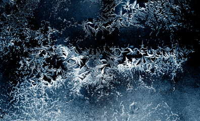Frozen winter window. Window frozen glass, ice crystals. Beautiful Hoarfrost pattern, rime on black...