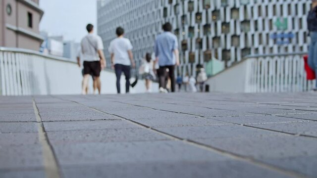 道を歩く人々。梅田の歩道橋の風景。