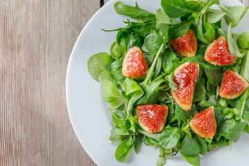 Healthy fig salad with lamb's lettuce and arugula and other vegetables.
