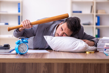 Young male employee in oversleeping concept