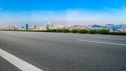 Panoramic skyline and empty asphalt road with modern buildings