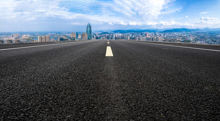 Panoramic skyline and empty asphalt road with modern buildings
